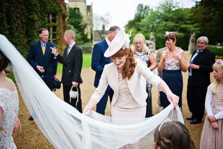 Candid photo of the brides mum looking after the brides wedding veil.