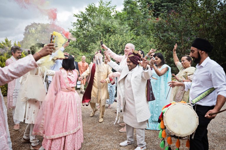 Candid, storytelling photo of an Indian Baraat with everyone from the grooms side celebrating at Manor By The Lake.