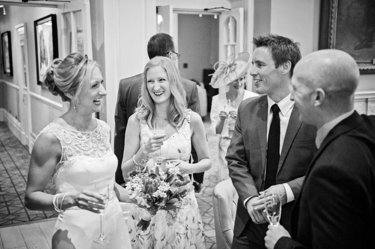 Candid, storytelling photo of bride chatting to wedding guests.