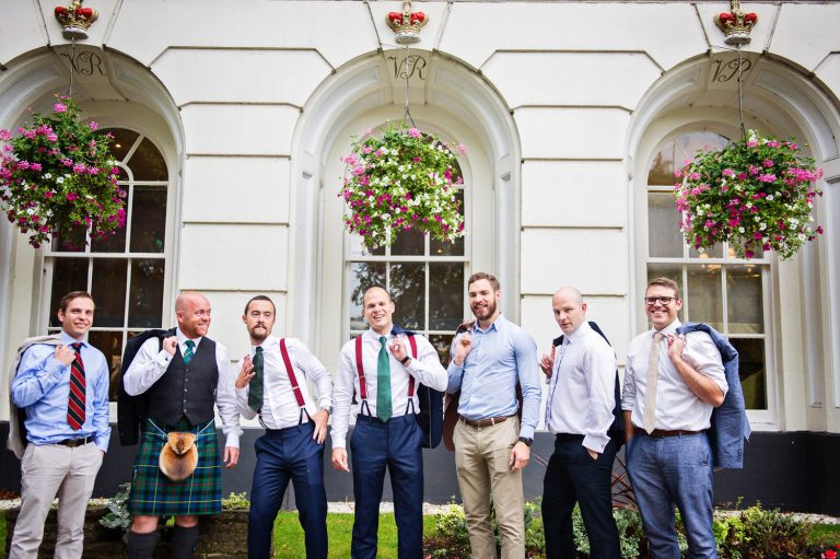 Groomsmen pose out the front of Queens Hotel.