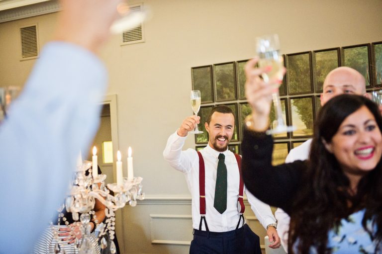 Wedding guests raise a glass during speeches at Queens Hotel.