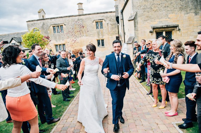 Bride and groom get showered in confetti at. their wedding at Ellenborough Park