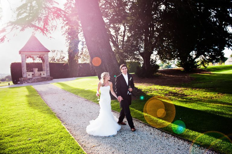 Bride and groom walk hand in hand during their wedding at Ellenborough Park.