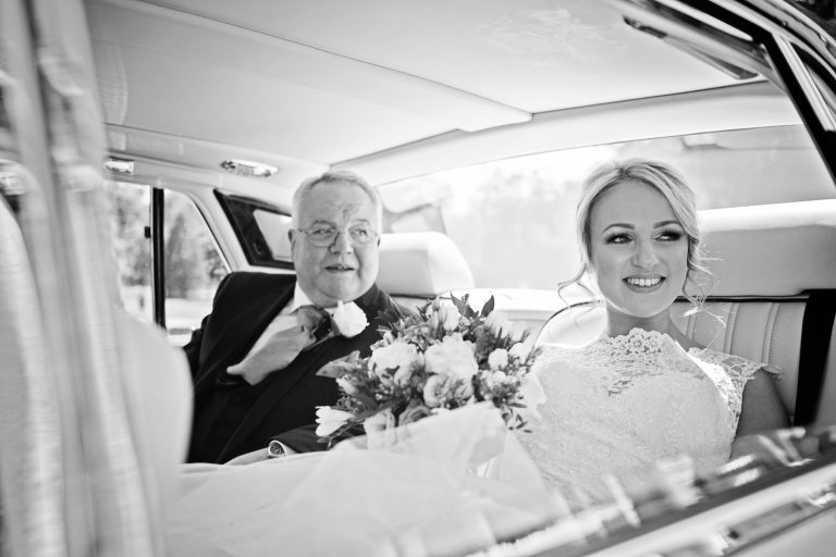 B&W photo of bride and her father as they wait to get called in to her wedding.