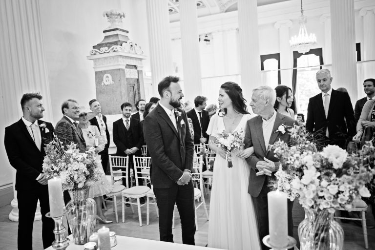 Bride and groom meet for the first time during their wedding ceremony at Pittville Pump Rooms. B&W image.