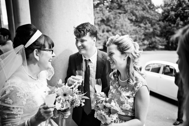 Candid photo of wedding guests laughing at Pittville Pump Room wedding.