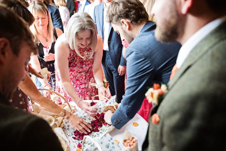 Story telling image of wedding guests collecting confetti.