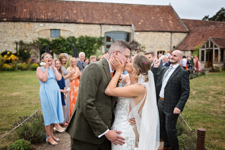 Bride and groom kissing after the confetti isle at Priston Mill.