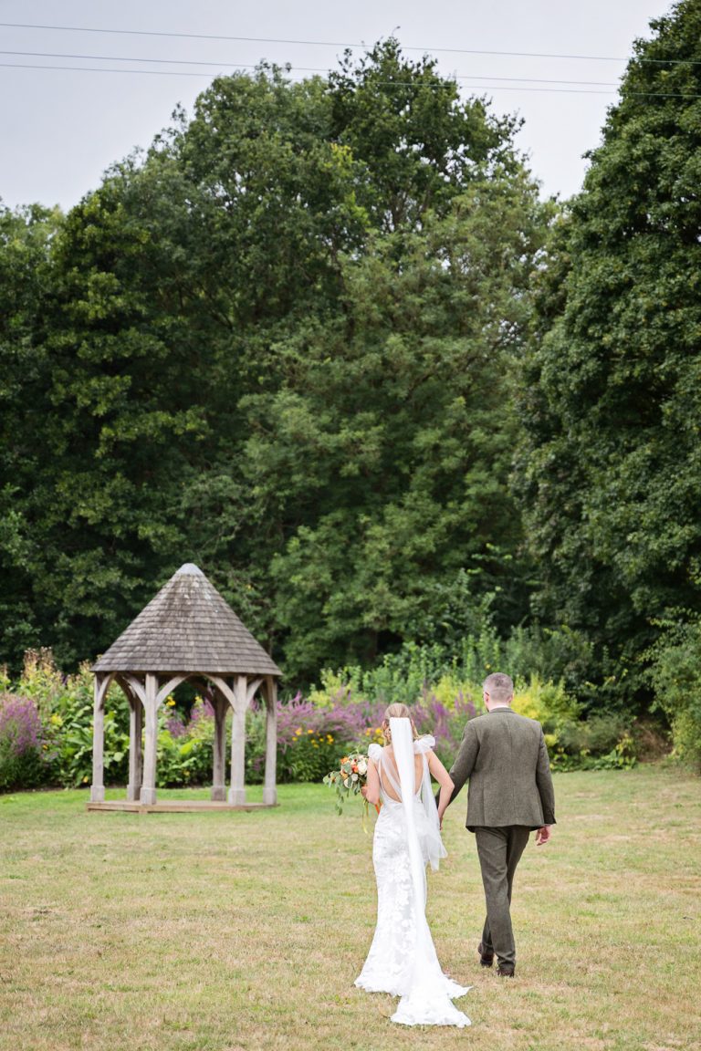 Bride and groom walk off at Priston Mill.
