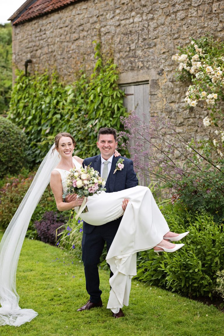 Groom carrying his bride at Priston Mill.