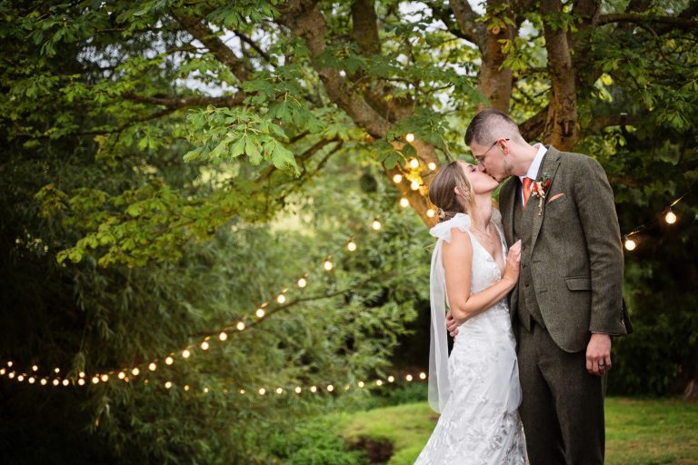 Bride and groom kiss in the evening at Priston Mill.