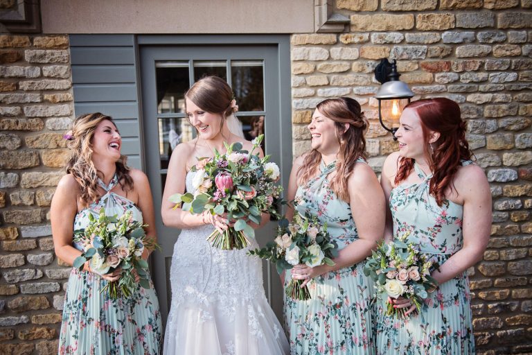Bridesmaids and bride giggling with the bride at The Slaughters Country Inn