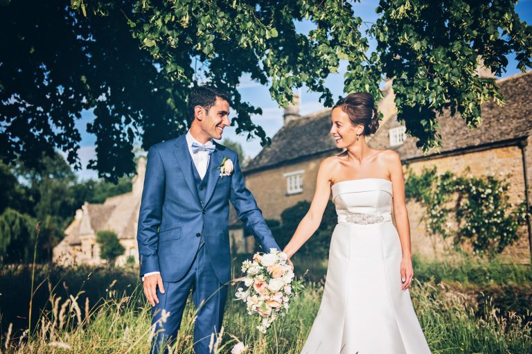 Bride and groom holding hands after getting married at The Slaughters Country Inn