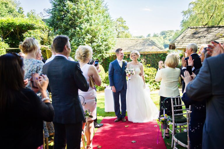 Bride and groom get congratulated by their wedding guests.