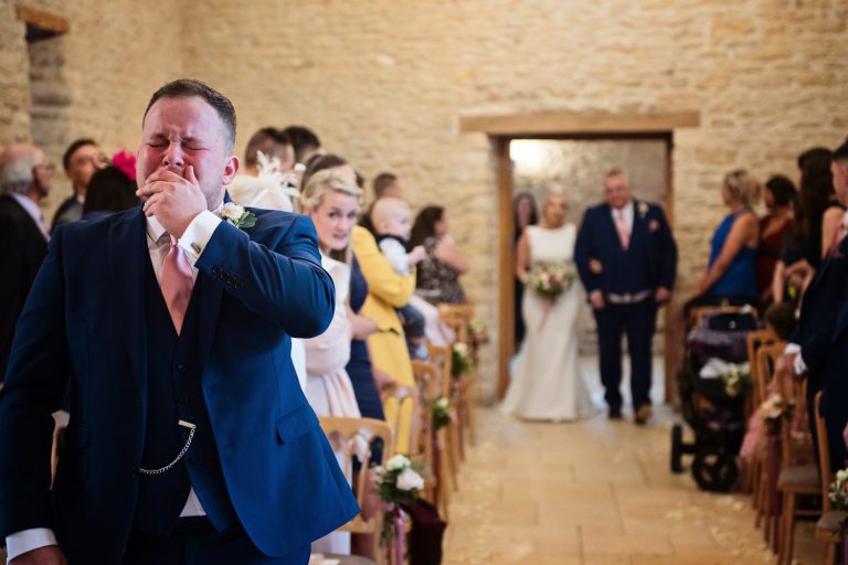 Groom getting emotional as bride is about to walk down the isle at Kingscote Barn
