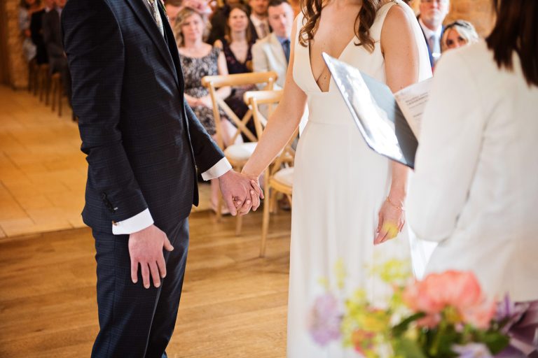 Candid photo of bride and groom holding hands.