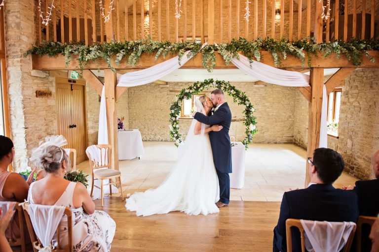 Candid photo of bride and groom kissing.