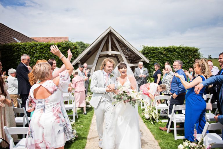 Kingscote Barn outdoor ceremony with bride and groom getting showered by lavender.