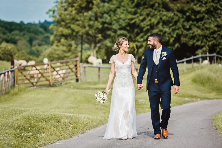 Bride and groom walk up the drive.