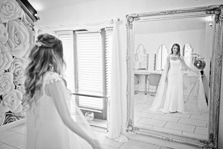 Bride looking at her reflection in the mirror.