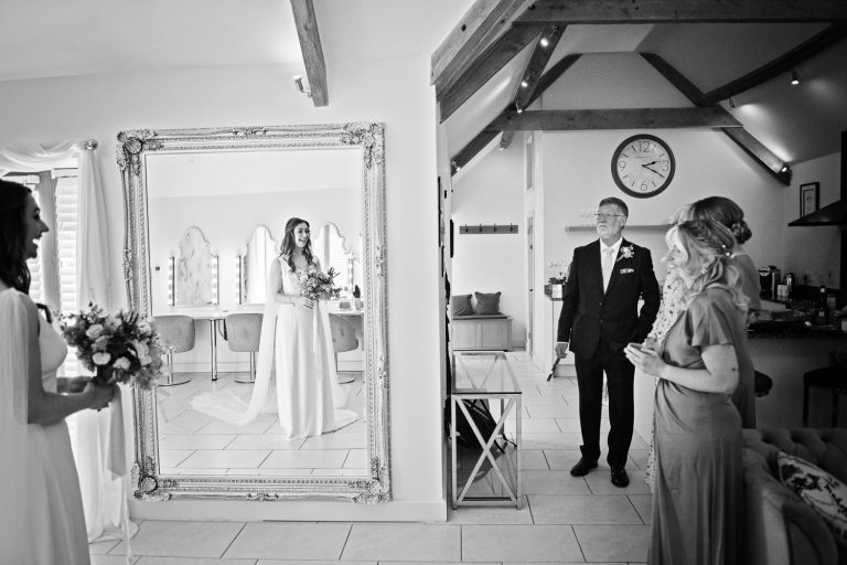 Documentary photo of father of the bride seeing his daughter for the first time before she gets married.
