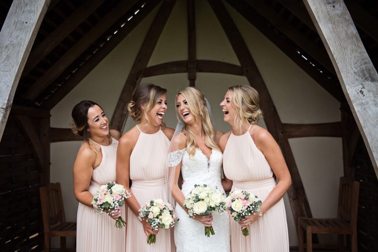 Bride and her bridesmaids laughing.