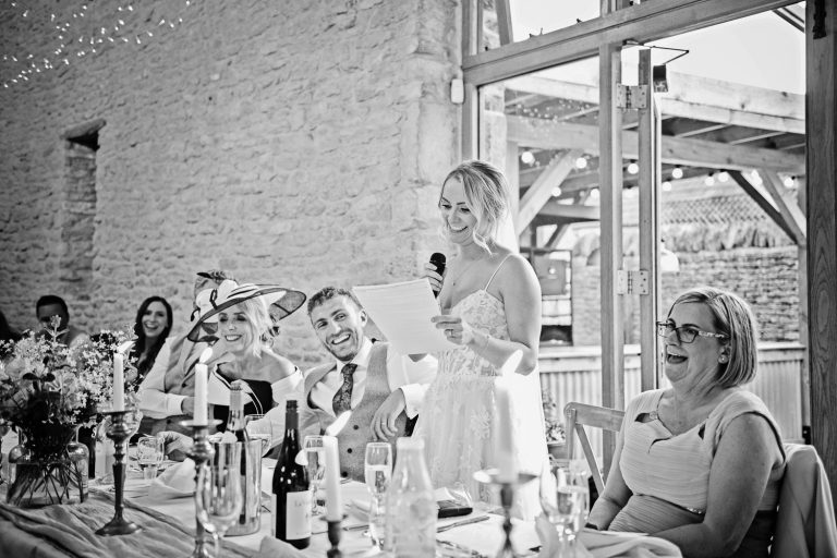 Bride doing her wedding speech at Kingscote Barn. Candid photo.
