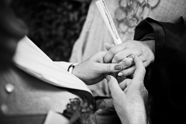 Documentary candid photo of holding hands at a wedding