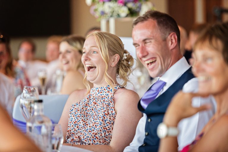 Candid photo of wedding guests laughing at Tewkesbury Park in the Cotswold Suite.