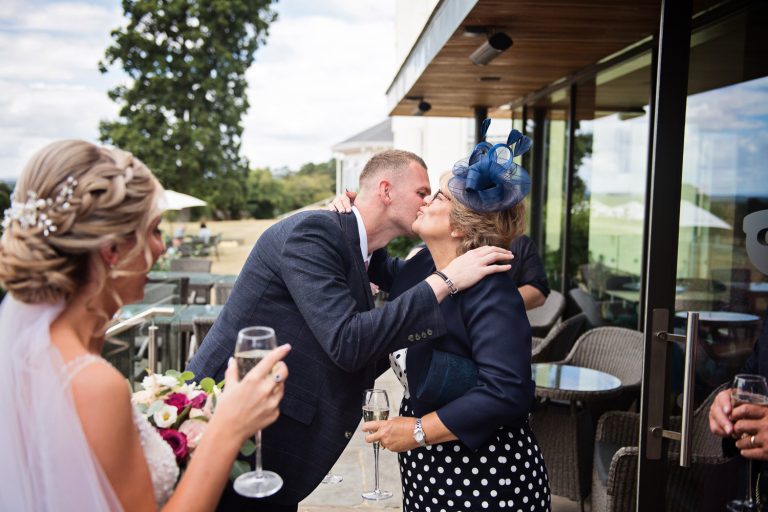 Documentary image of wedding guests congratulating the groom at Tewkesbury Park