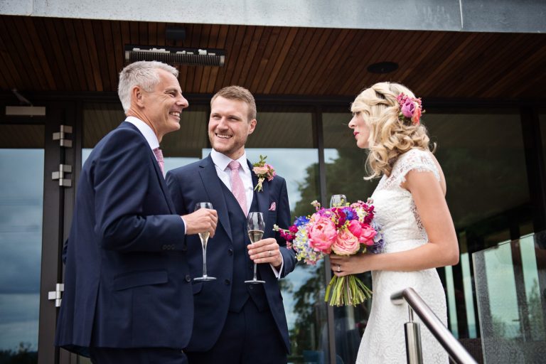 Candid image of bride and groom talking to wedding guests at Tewkesbury Park