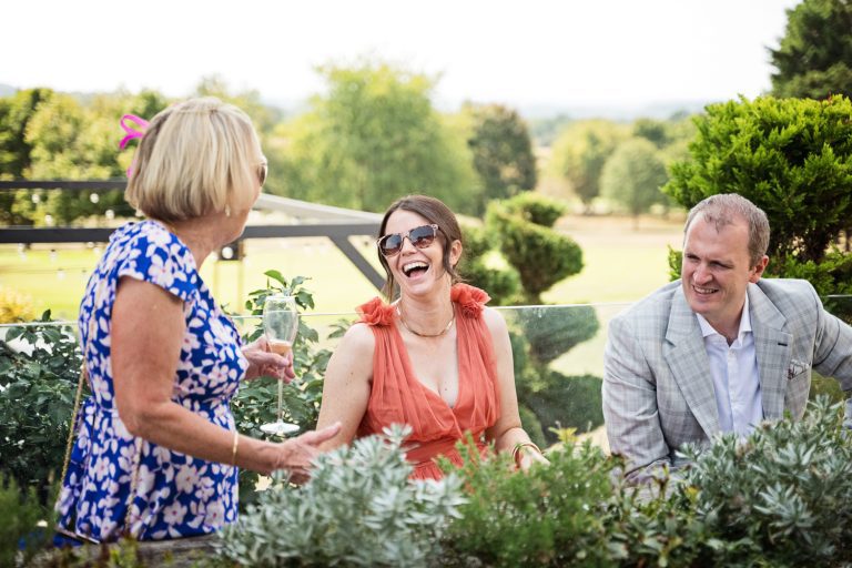 Story telling image of wedding guests laughing at Tewkesbury Park