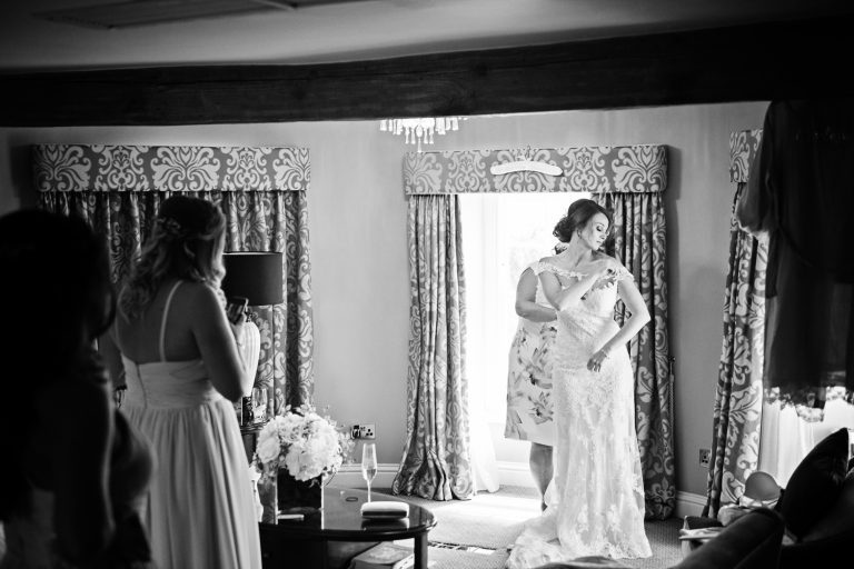B&W documentary photo of bride getting ready in the bridal suite at Tewkesbury Park