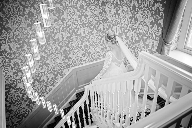 Documentary photo of Bride walking down the stairs at Tewkesbury Park
